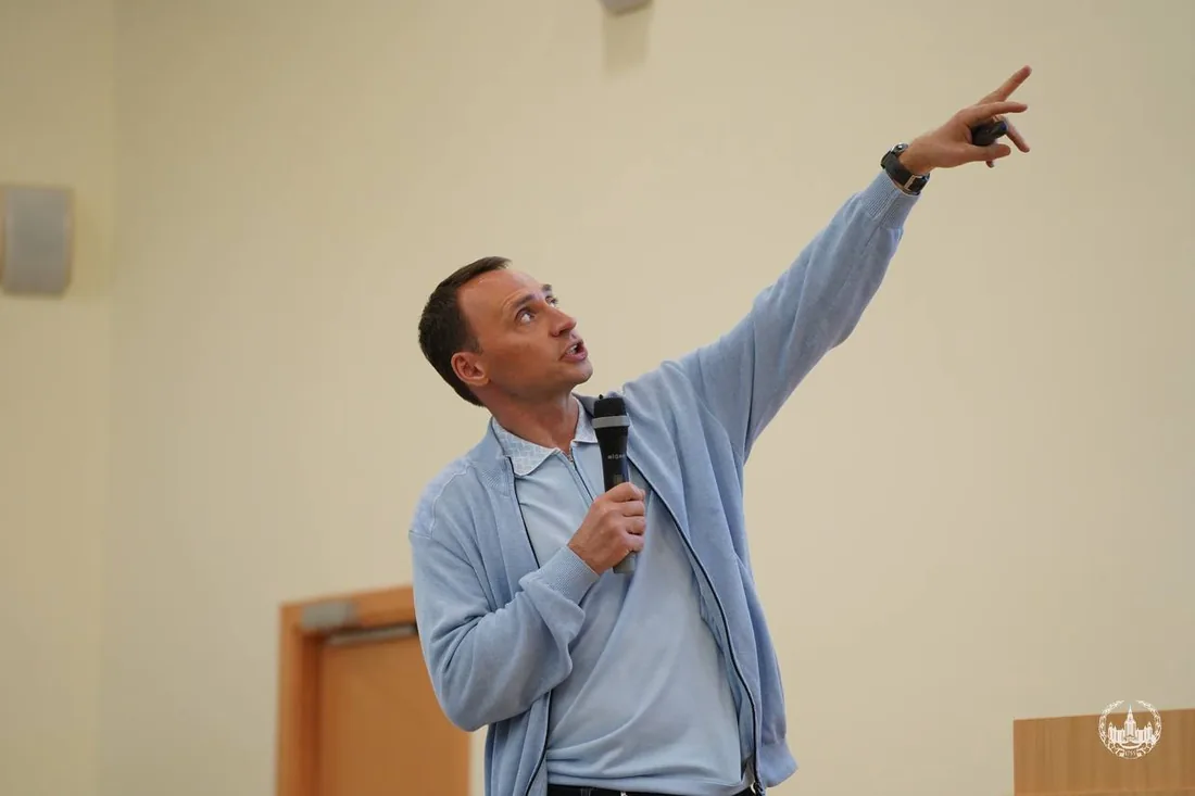 Спикер указывает на экран во время выступления
